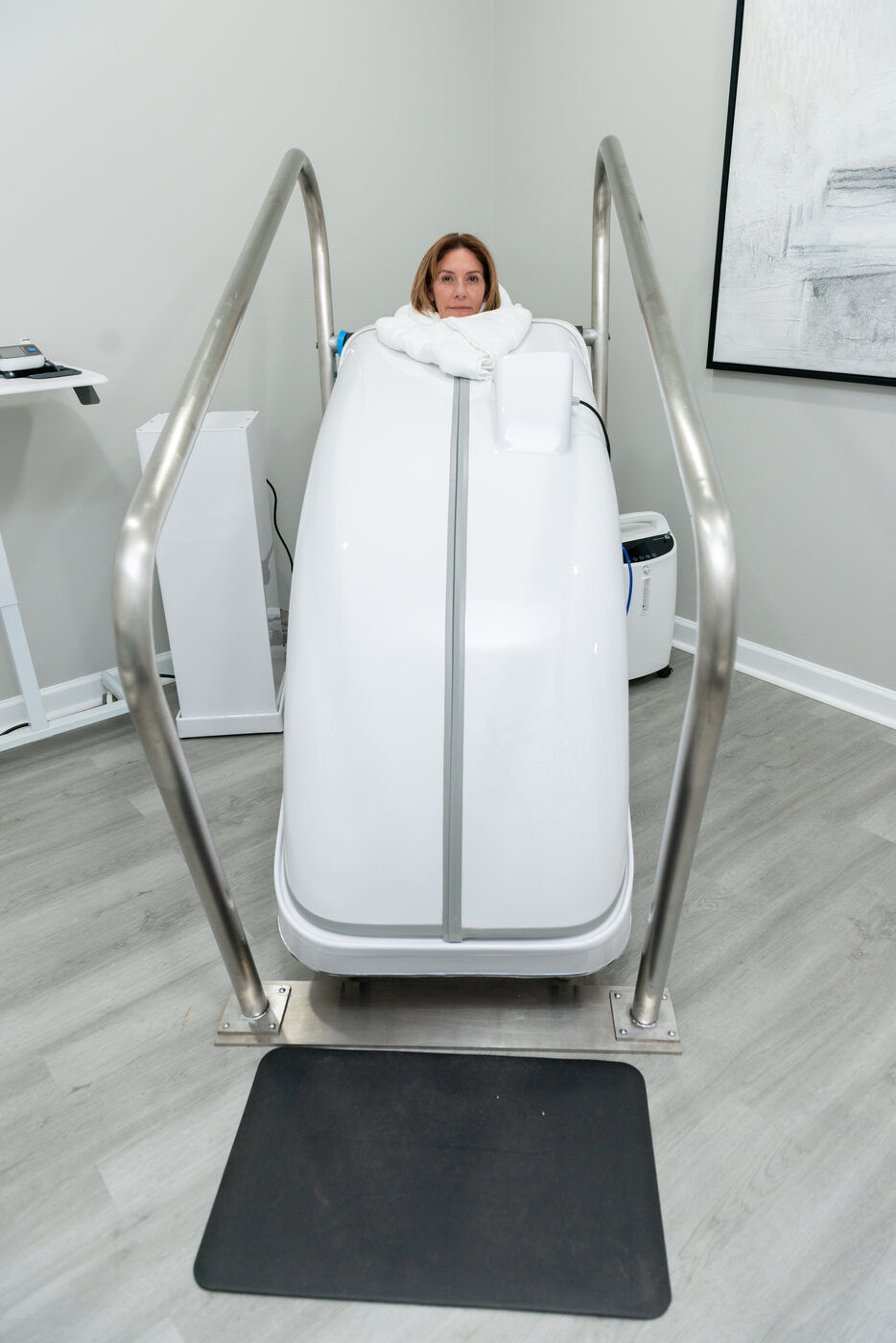 Patient in HOCATT full-body ozone sauna with head above chamber at THRIVE Alpharetta