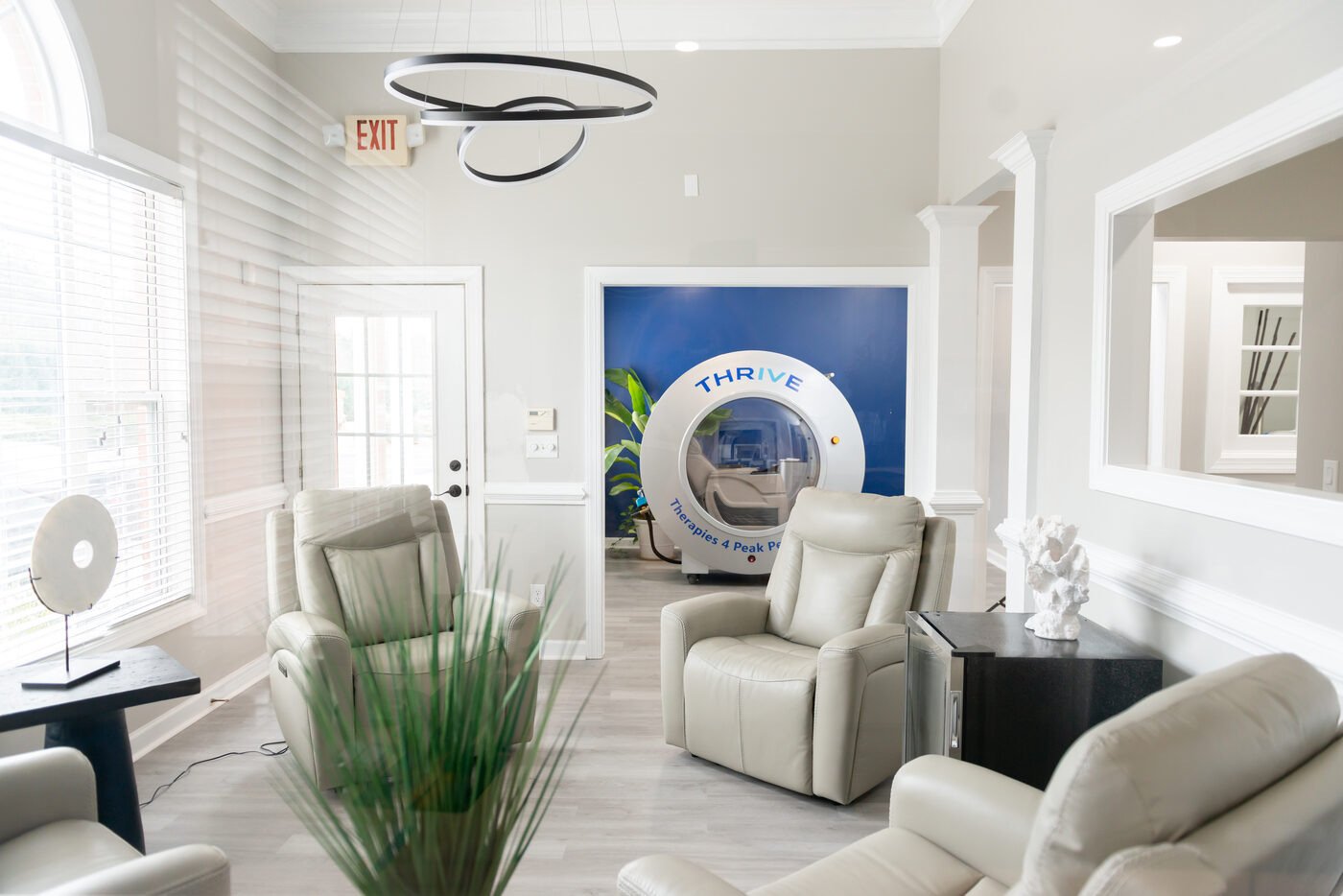 THRIVE clinic lobby with THRIVE-branded hyperbaric chamber visible through doorway