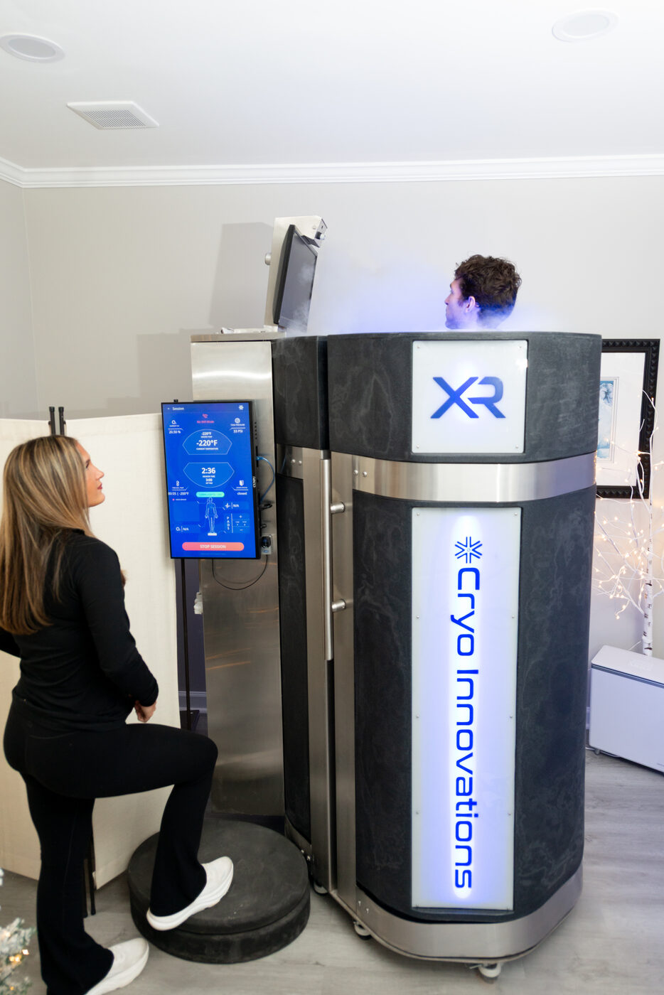 Female patient in cryotherapy chamber with medical staff supervision at THRIVE Alpharetta